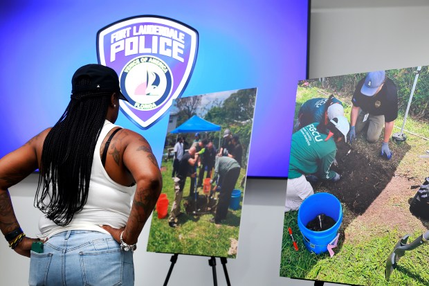 Lynnette Finnie looks at a display showing photos of the recovery process where the remains of her niece, Trukita Scott, were discovered, during a press conference at the Fort Lauderdale Police Department on Tuesday, May 19, 2026. (Carline Jean/South Florida Sun Sentinel)