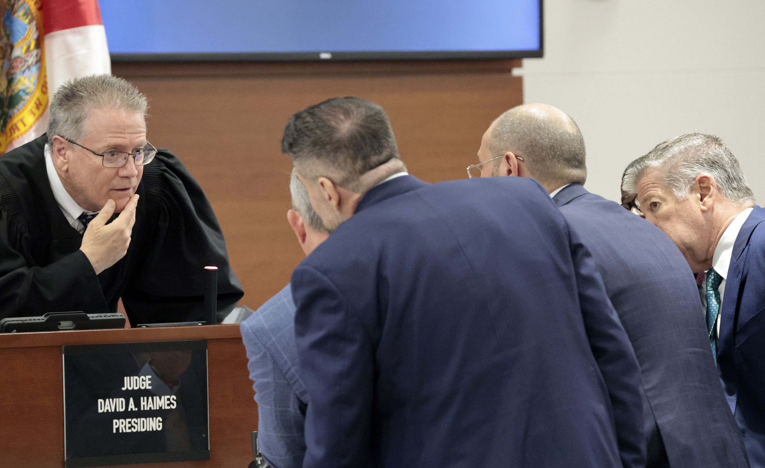 Judge David Haines speaks to attorneys from both sides during...