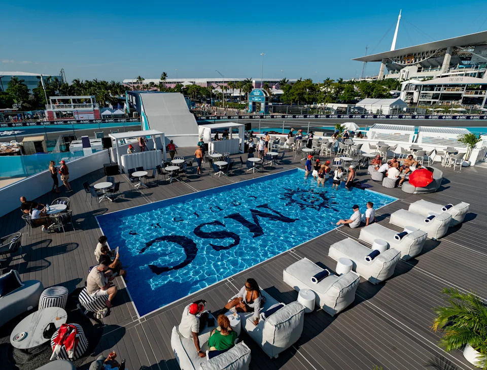 In person, the water feature changed the entire tone. At most race venues, you are thinking about heat, lines, crowds, and where you can get a better view. Here, the visual language felt closer to a luxury cruise deck: open air, water, seating, conversation, and track views in the background.