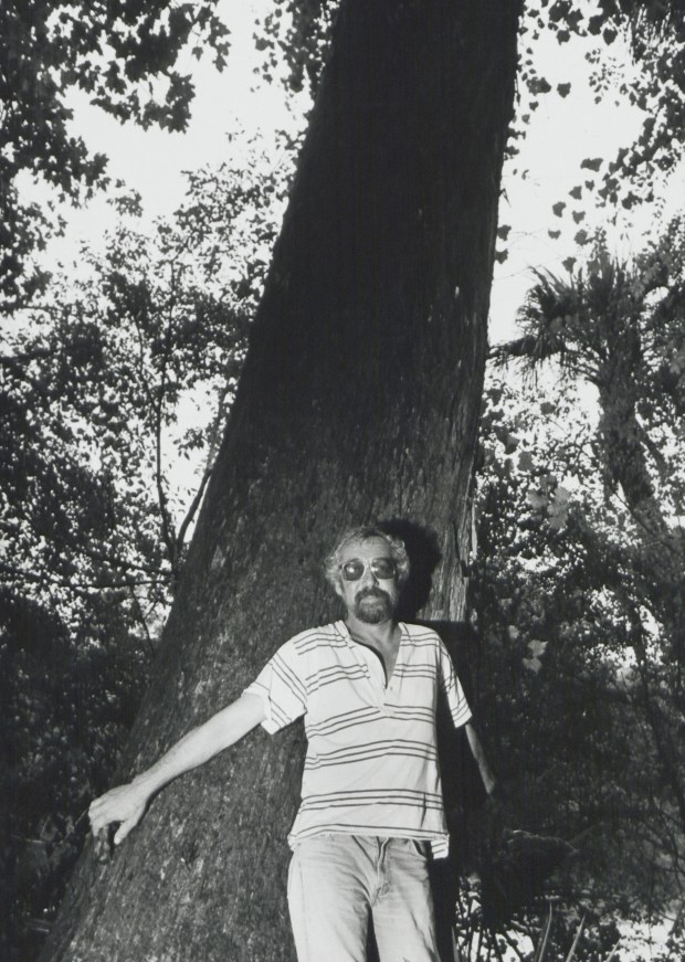 Ken Bosserman poses next to a large cypress tree along the bank of the Econlockhatchee River, a place he fought to protect, in 1998. (Orlando Sentinel file)
