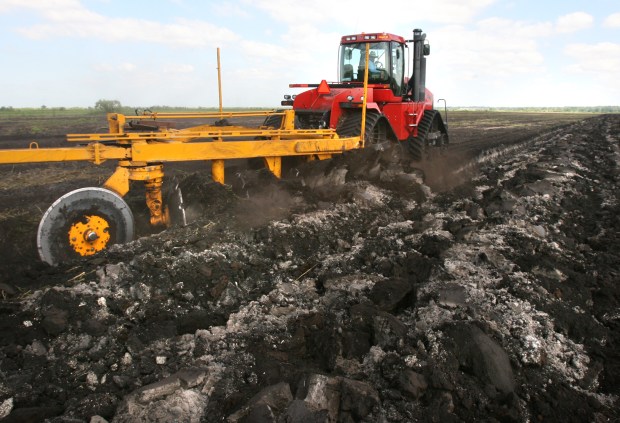 Jason Freeman of Roscoe, Texas, operates a huge tractor used to turn over polluted soil on one of the old Apopka muck farms on April 18, 2008. Work is underway to remedy pesticide contamination at former farms north of Lake Apopka, an area to be restored as part of the lake and lake's marsh. (Orlando Sentinel file)