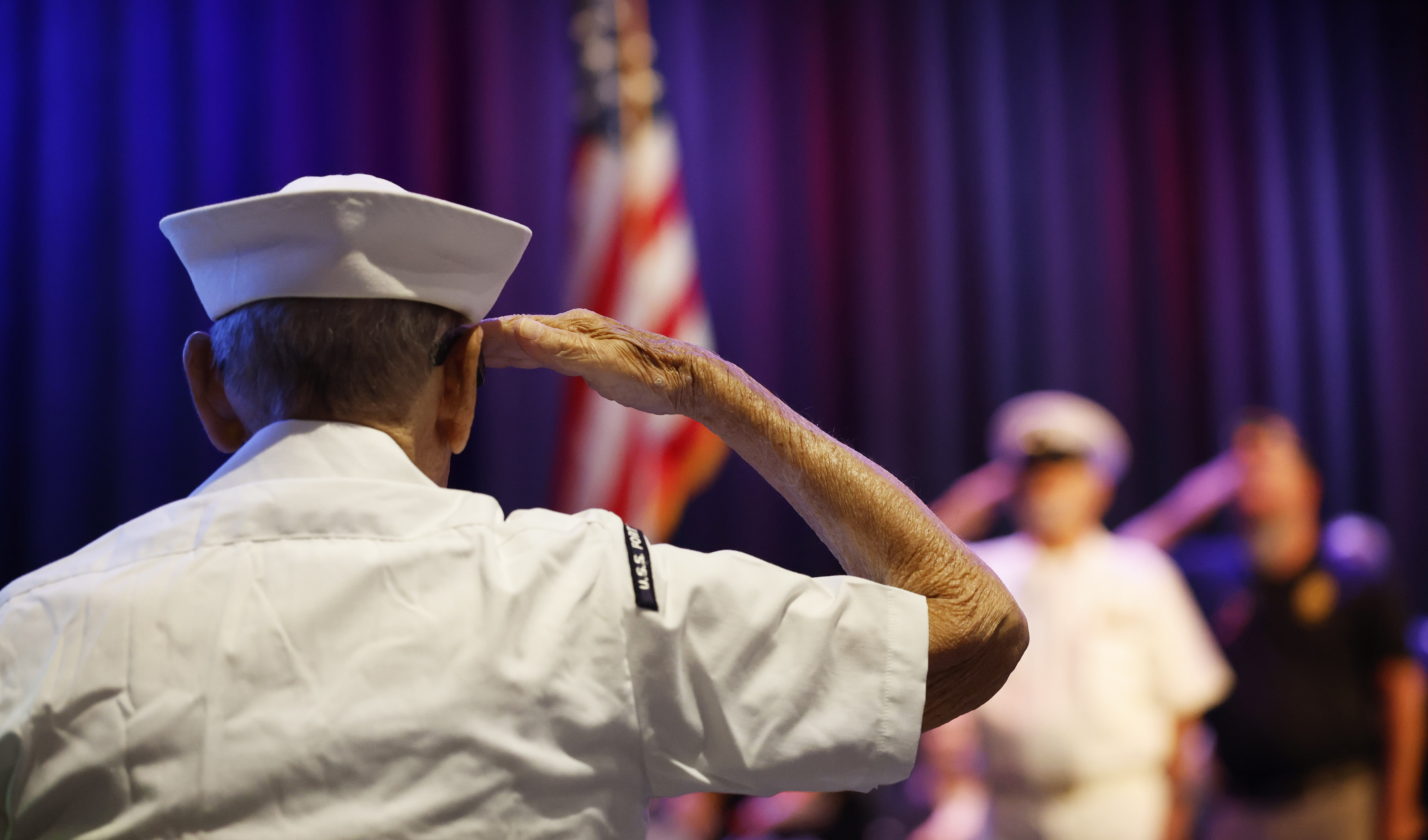 US Navy veteran William Matheos salutes during the Memorial Day...