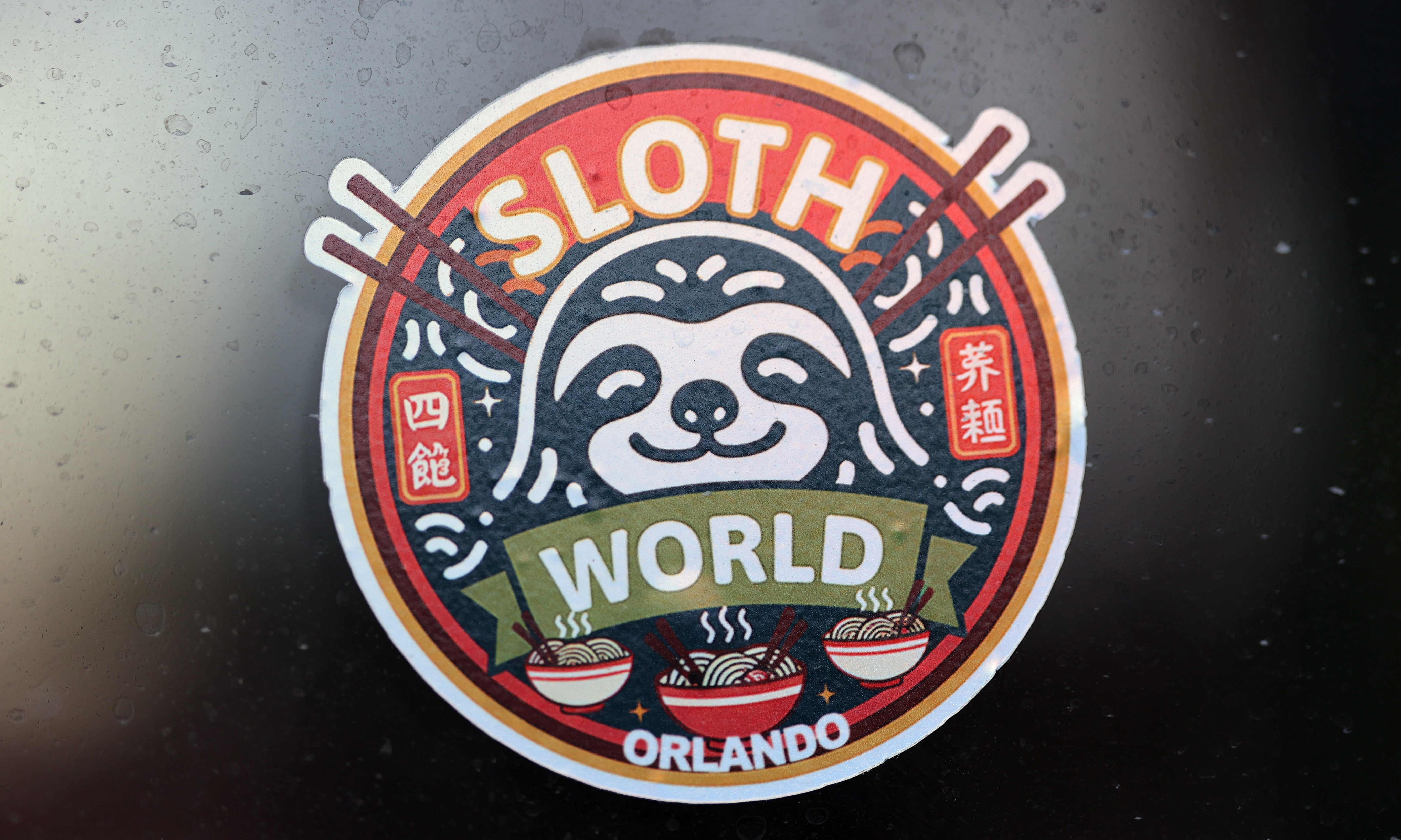 Sticker on the outside windows of Sloth World on International...