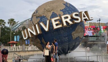 The iconic Universal globe spins at the entrance to Universal Studios, with excited guests gathering for a day of adventure.