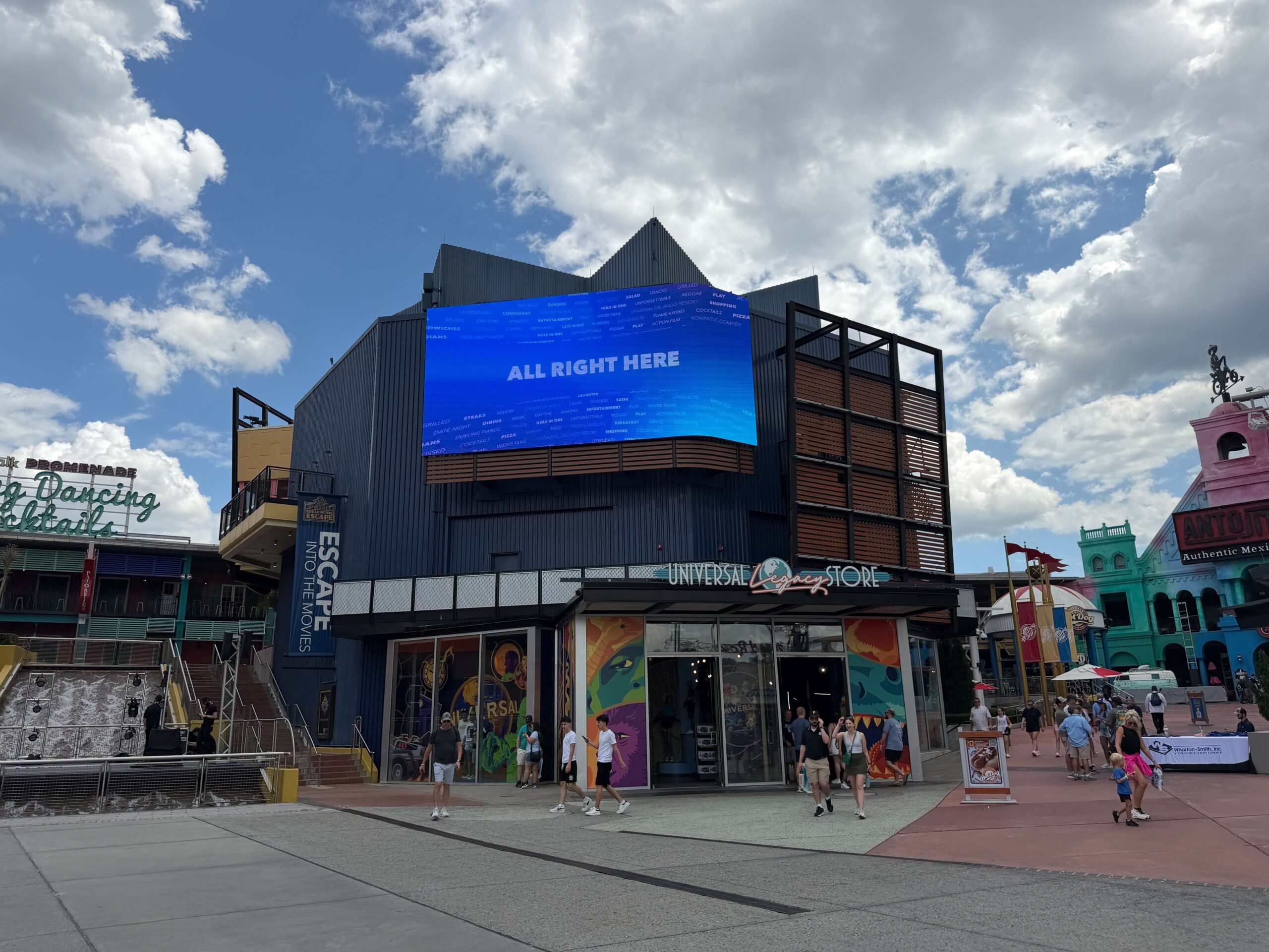 Exterior of the Legacy Store, located in Universal Orlando Resort's CityWalk. The store has a retro logo and a large screen above it.