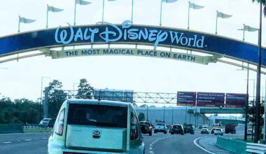 Cars driving under the entrance archway of the Walt Disney World Resort. Disney World traffic delays summer 2026