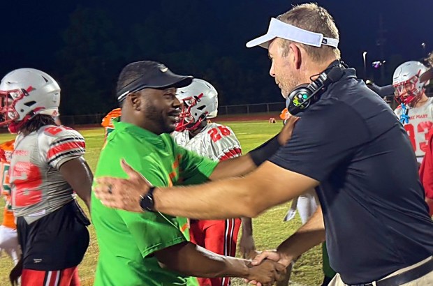 Jones head coach Elijah Williams (left) and Lake Mary coach Scott Perry, who were teammates at Florida in the mid 90s, shake hands after Wednesday night's spring game. (Chris Hays/Orlando Sentienl)