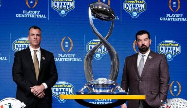 Ohio State Buckeyes head coach Ryan Day, right, and Miami (FL) Hurricanes head coach Mario Cristobal pose with the Field Scovell Trophy after talking to media during a Cotton Bowl press conference at AT&T Stadium in Arlington, Texas prior to their College Football Playoff quarterfinal matchup on Dec. 30, 2025.