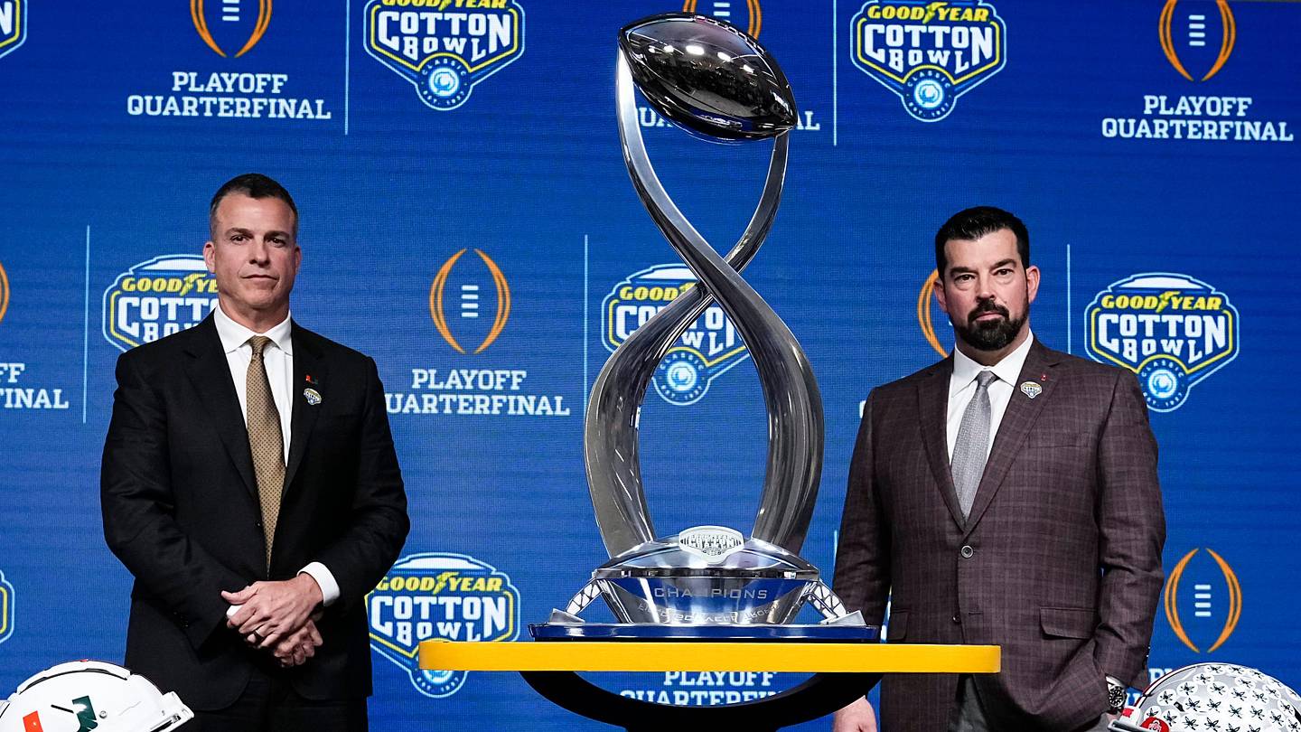 Ohio State Buckeyes head coach Ryan Day, right, and Miami (FL) Hurricanes head coach Mario Cristobal pose with the Field Scovell Trophy after talking to media during a Cotton Bowl press conference at AT&T Stadium in Arlington, Texas prior to their College Football Playoff quarterfinal matchup on Dec. 30, 2025.