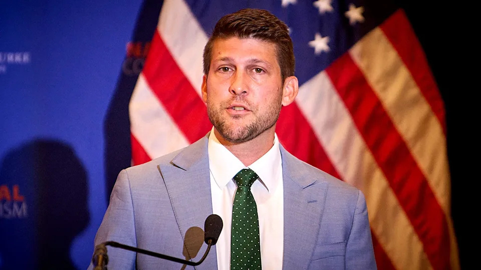 James Uthmeier speaking at a podium at the National Conservative Convention in Washington, D.C.