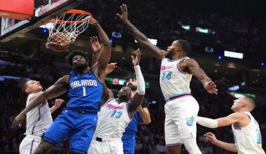 Orlando Magic forward Jonathan Isaac (1) dunks over Miami Heat center Bam Adebayo (13) and forward Haywood Highsmith (24) during the first half of a game on Monday, Jan. 27, 2025, in Miami. (AP Photo/Lynne Sladky)