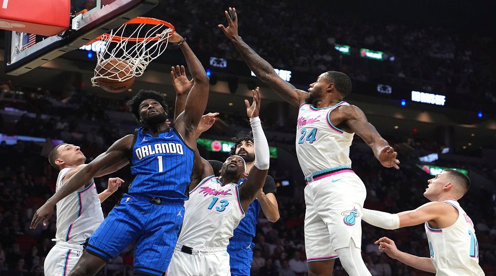 Orlando Magic forward Jonathan Isaac (1) dunks over Miami Heat center Bam Adebayo (13) and forward Haywood Highsmith (24) during the first half of a game on Monday, Jan. 27, 2025, in Miami. (AP Photo/Lynne Sladky)