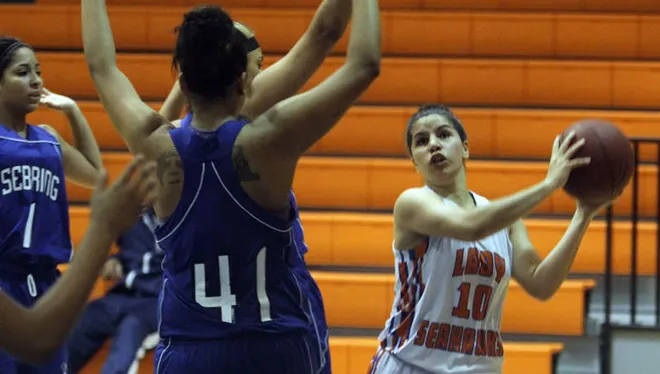 Cape Coral's McKenna Beach passes the ball against Sebring defenders Thursday night during the Region 5A-4 quarterfinals at Cape Coral High. Cape Coral won the game 55-36.