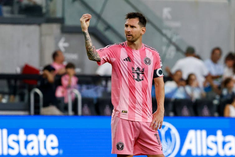 Lionel Messi in an Inter Miami uniform makes the 'money' hand gesture.