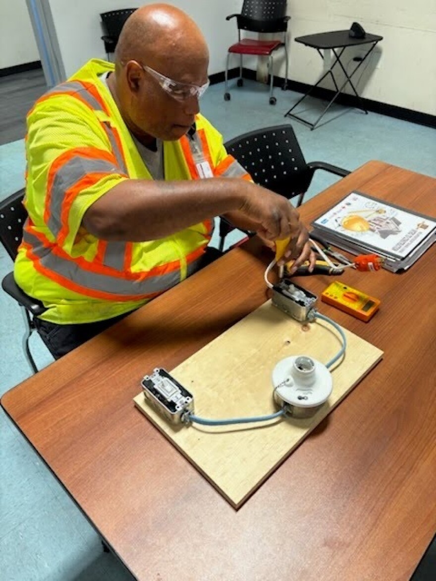 Mark Smith uses a tool on an electrical apparatus during workforce training at the CDC of Tampa.
