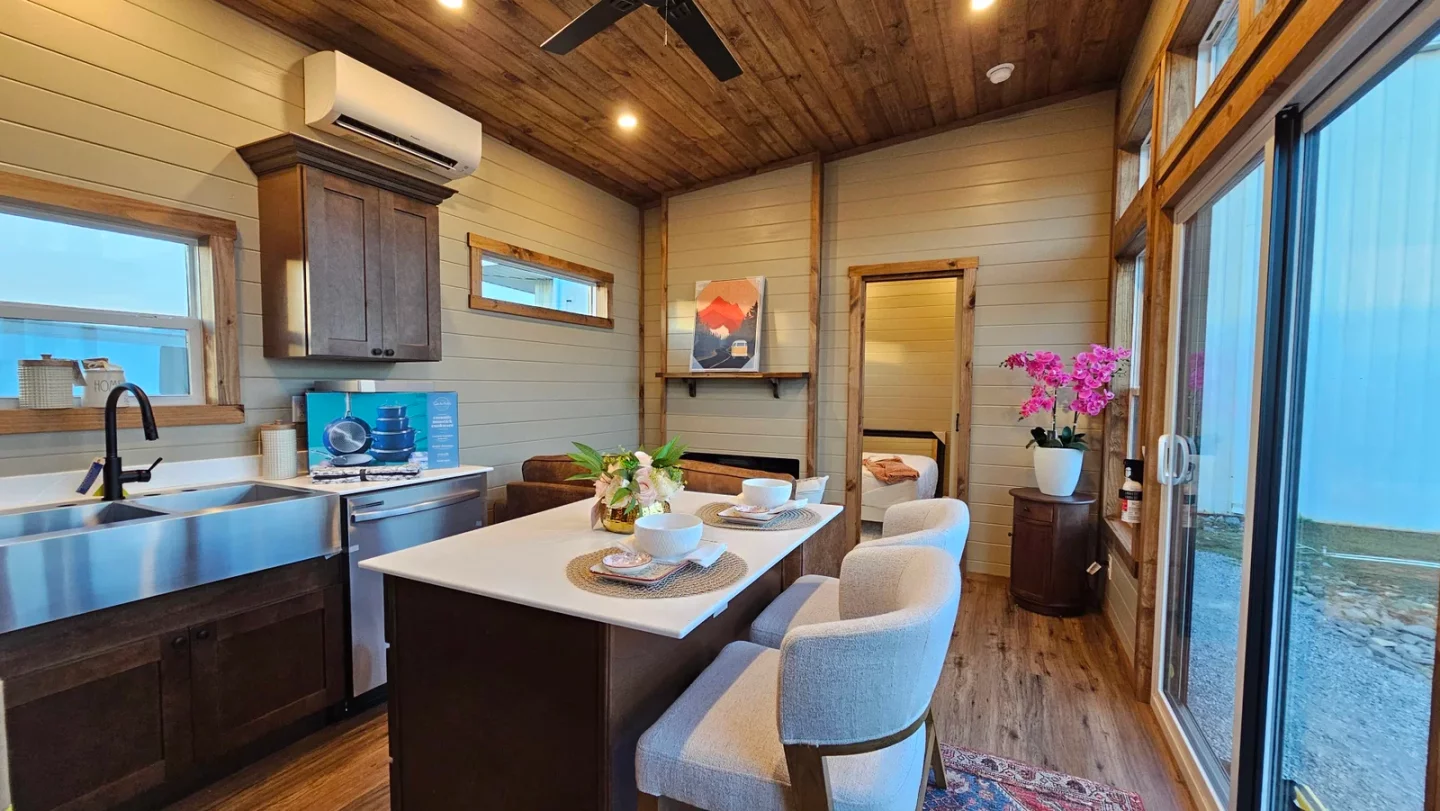 The Miami's kitchen includes a dual-basin stainless steel sink, an oven and cooktop, a microwave, a dishwasher, and a fridge/freezer