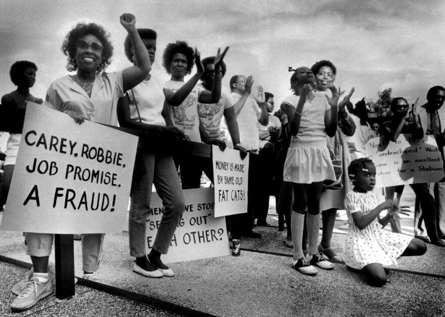 A group of women hold protest signs against Joe Robbie Stadium.