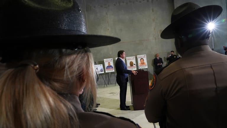 Florida Highway Patrol officers listen to Gov. Ron DeSantis speak...