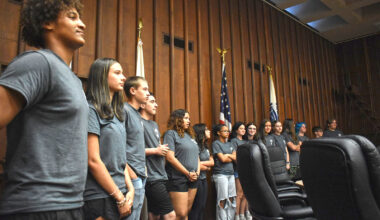 Students in the Jacksonville Police Department's Teen Police Academy line up while they wait for their names to be called during a graduation ceremony.