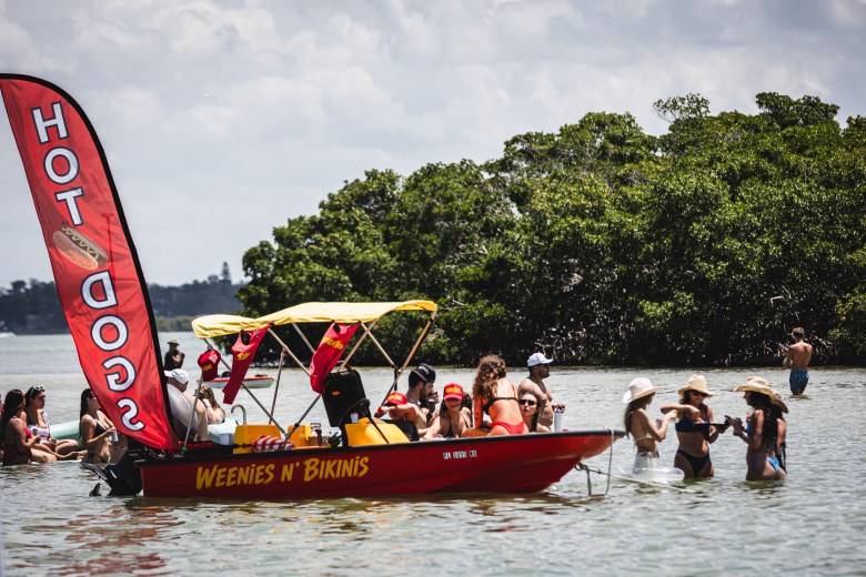 Boaters patronize the Weenies N' Bikinis hot dog boat at John's Pass Sandbar.