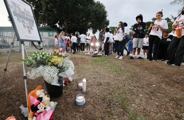 Mourners gather during a community vigil for 2-year-old Tiana Rae Watts and 1-year-old Jaliyah Katherine Watts outside the Palmetto at Lakeside Apartments in Orlando on Thursday, June 11, 2026. The two children were killed by their father last week. (Stephen M. Dowell/Orlando Sentinel)