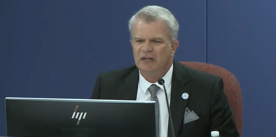 Gray haired man in suit, superintendent Brennan Asplen speaks at the school board's special meeting