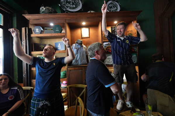 Scotland soccer fans with the Tartan Army play bagpipes, chant and dance in the Ball and Chain music bar before marching to a Miami Marlins against the Texas Rangers baseball game in Miami, Monday, June 22, 2026. (AP Photo/Rebecca Blackwell)