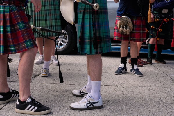 Scotland soccer fans with bagpipes wear kilts as they wait to enter the stadium for a Miami Marlins against the Texas Rangers baseball game after marching with the Tartan Army, Monday, June 22, 2026, in Miami. (AP Photo/Rebecca Blackwell)