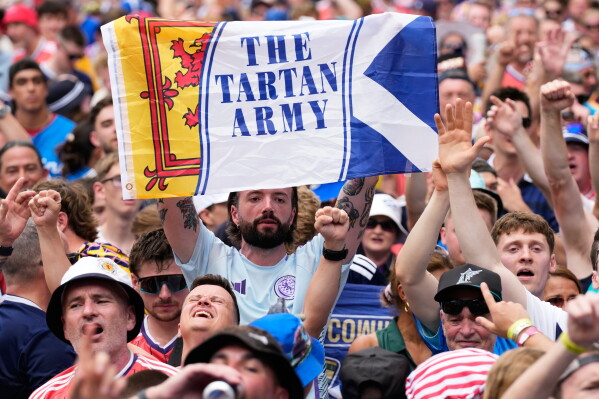 A Scotland soccer fan holds a Tartan Army sign as part of the Tartan Army march before a baseball game between the Miami Marlins and the Texas Rangers, Monday, June 22, 2026, in Miami. (AP Photo/Lynne Sladky)