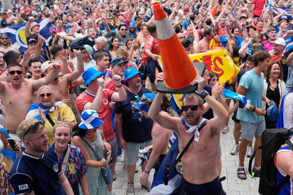 A Scotland soccer fan dances with a traffic cone as part of the Tartan Army march outside of loanDepot park before a baseball game between the Miami Marlins and the Texas Rangers, Monday, June 22, 2026, in Miami. (AP Photo/Lynne Sladky)