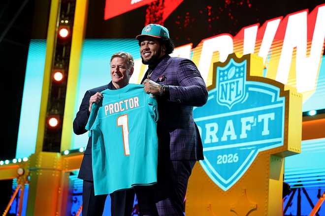 PITTSBURGH, PENNSYLVANIA - APRIL 23: Kadyn Proctor (R) of Alabama poses with NFL Commissioner Roger Goodell (L) after being selected twelfth overall pick by the Miami Dolphins during Round One of the 2026 NFL Draft at Acrisure Stadium on April 23, 2026 in Pittsburgh, Pennsylvania.  (Photo by Emilee Chinn/Getty Images)