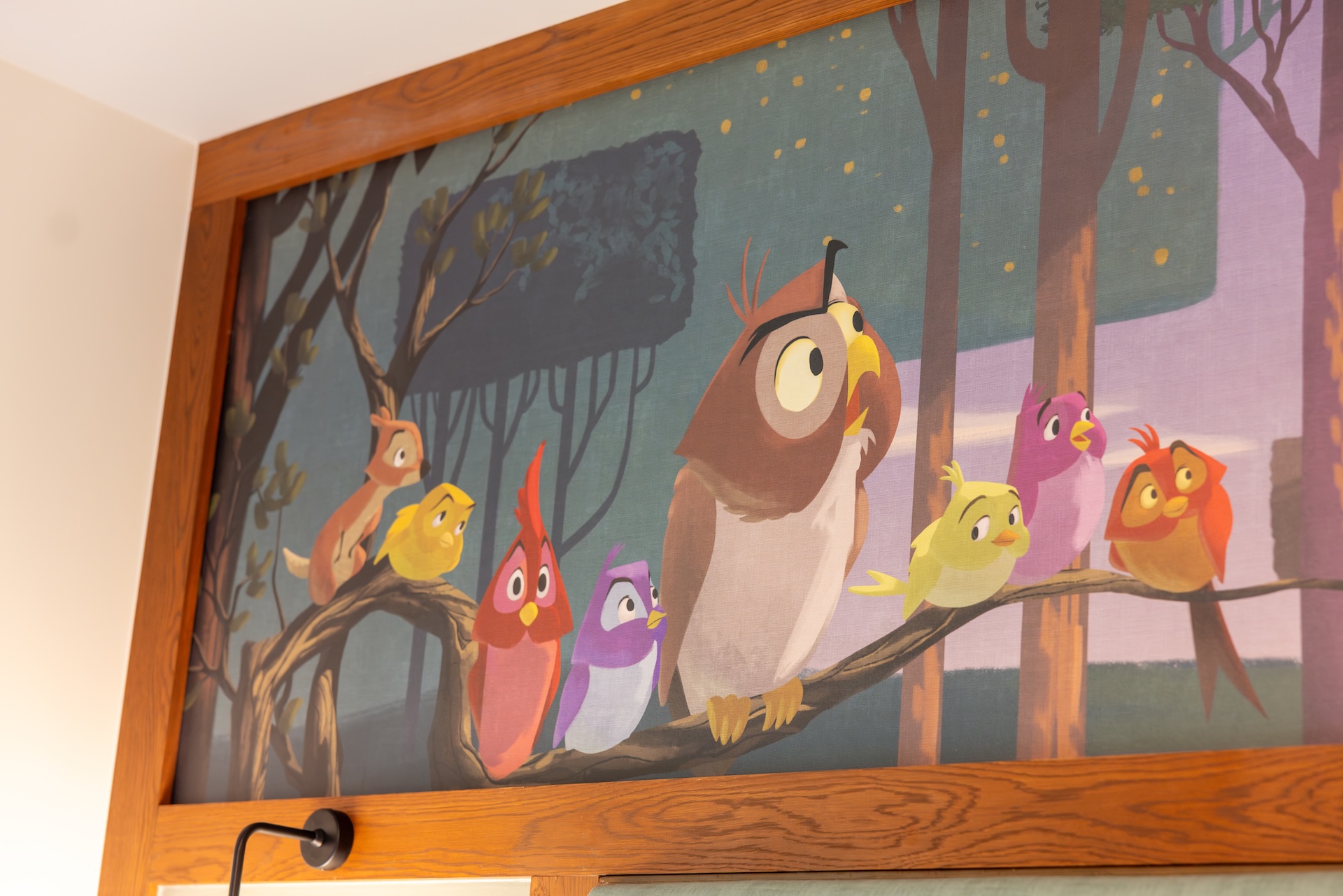 Framed Mural of Colorful Cartoon Birds Perched on Branches in a Forest Scene