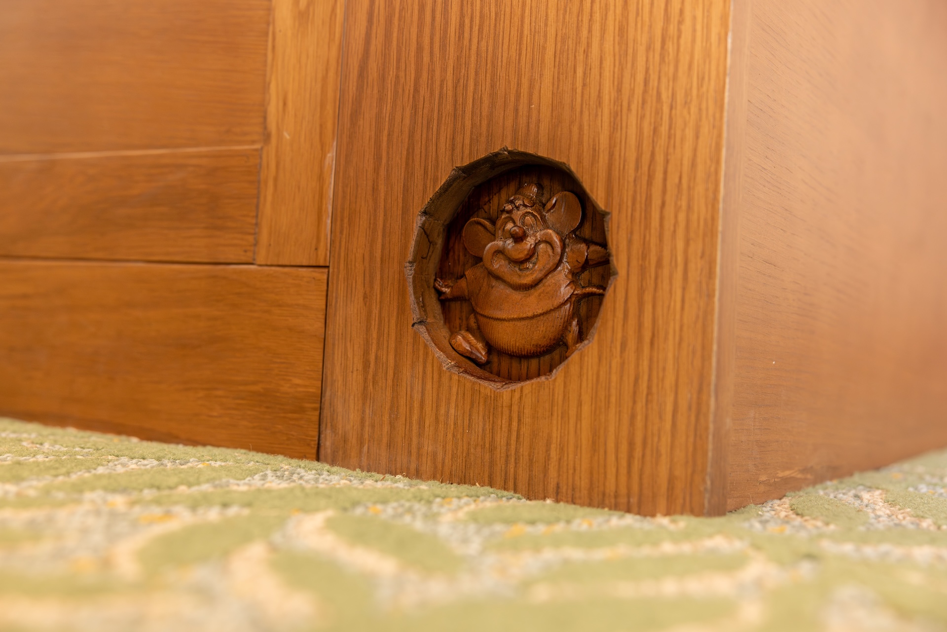 Wooden Furniture Leg with a Circular Hole Showing a Carved Frog Figurine Peeking out
