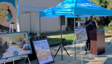 Arble Baking Co. co-founder Alonza Anderson stands under a tent talking about the new credit union office and sandwich bakery.