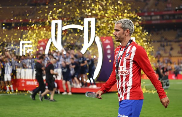 SEVILLE, SPAIN - APRIL 18: Antoine Griezmann of Atletico de Madrid walks past the podium as players of Real Sociedad celebrate with the Copa Del Rey trophy following the Copa Del Rey Final match between Real Sociedad and Atletico de Madrid at Estadio de La Cartuja on April 18, 2026 in Seville, Spain. (Photo by Fran Santiago/Getty Images)