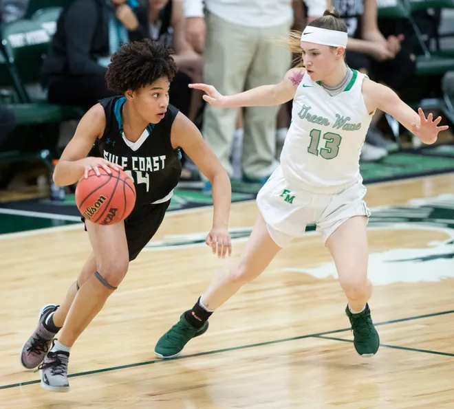 Gulf Coast High School's Yasmeen Chang, left, drives to the basket against Fort Myers' Tatum Hayes 71-67 recently in Fort Myers. Gulf Coast beat Fort Myers 71-67.