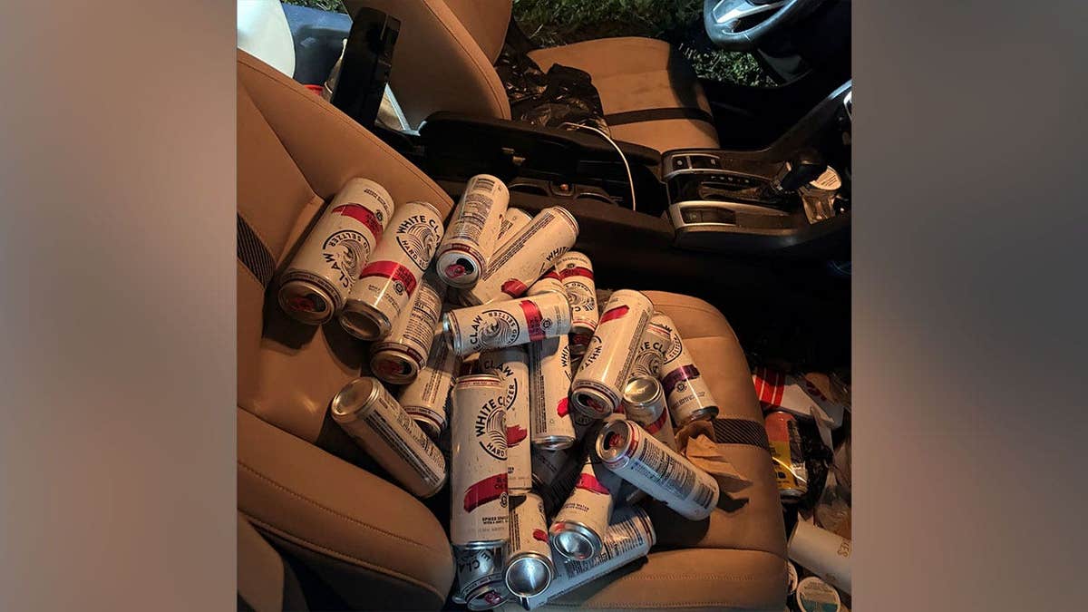 34 White Claw Cans sitting on a car seat