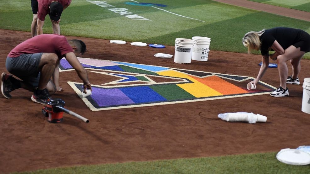PHOENIX, ARIZONA - JUNE 17: Arizona Diamondbacks grounds crew and staff members use colored sand to decorate the team logo in conjunction with Pride Night at Chase Field during a game against the Cleveland Guardians on June 17, 2023 in Phoenix, Arizona. (Photo by Norm Hall/Getty Images)