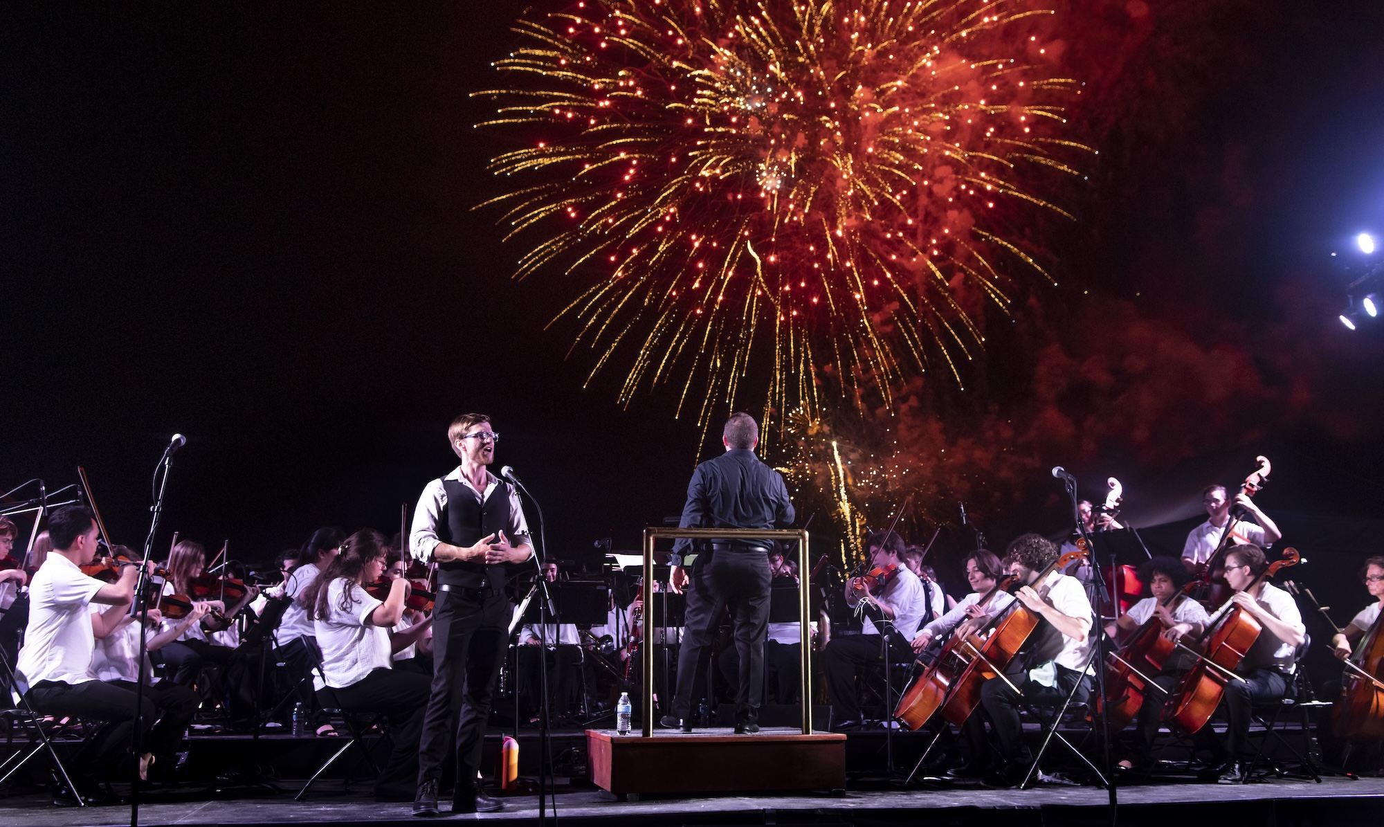 Photo of an orchestra performing in Miami Beach in front of Fire works