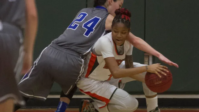 Dunbar's Dekeriya Patterson tries to keep control of the ball against Georgetown in the Queen of Palms Ruby Division on Tuesday night, December 30, 2014, at Dunbar High School in Fort Myers.