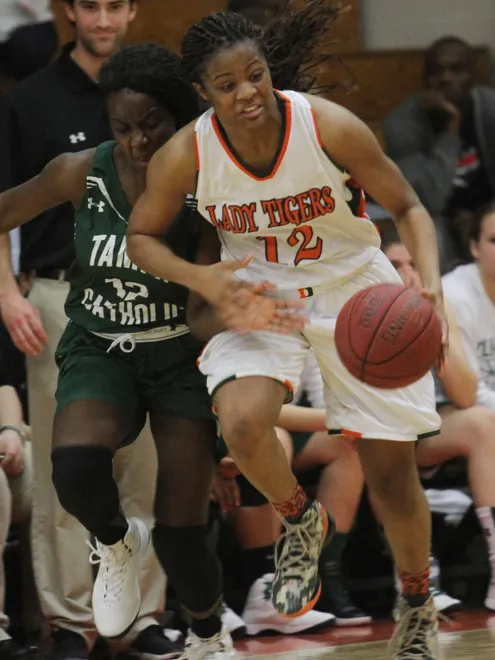 Dunbar's Kiara Desamours steals the ball from Tampa Catholic's Mia Blocker during the Region 4A-3 girls basketball championship game at Dunbar High School on Friday night.