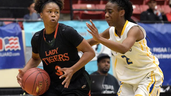 Dunbar's Keri Jewett (3) drives past Cardinal Newman's Anise Williams (2) during a girls basketball game at the FHSAA State Finals, Tuesday, Feb. 17, 2015, in Lakeland, Fla.(Photo/Phelan M. Ebenhack)