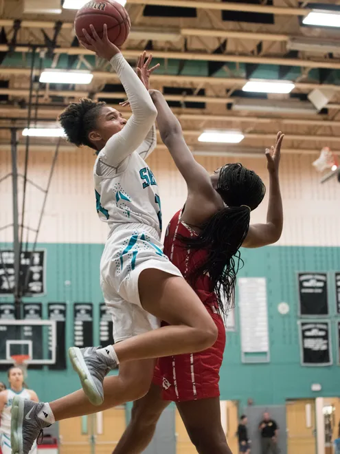 Yasmeen Change of Gulf Coast puts up a shot against Paris Sharpe of Cardinal Gibbons during the Naples Holiday Shootout game at Gulf Coast High School on Thursday, Dec. 28, 2017.