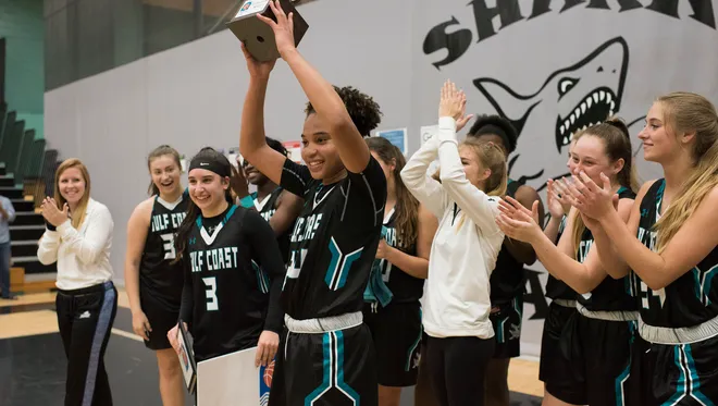 Yasmeen Chang, center, celebrates winning the tournament MVP award after Gulf Coast beat Ursuline Academy to win the National Division championship game of the Naples Holiday Shootout tournament at Gulf Coast High School on Saturday, Dec. 30, 2017.
