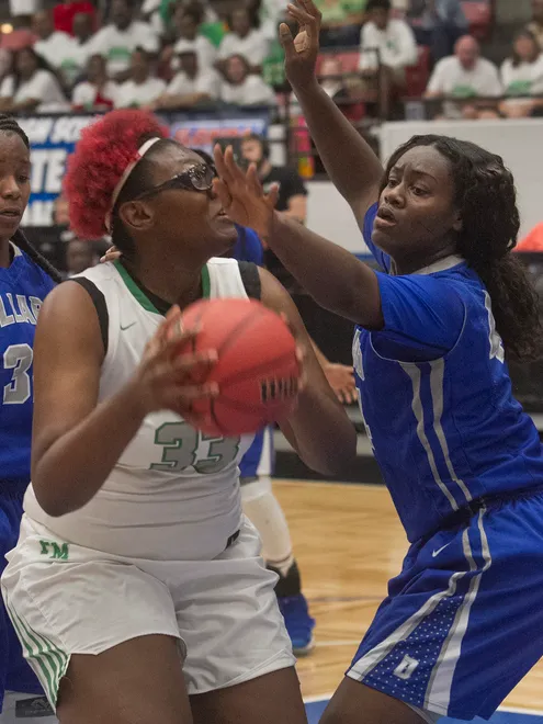 Fort Myers High School's Chaniya Clark (33) eyes the basket as Dillard High School's Raven White (44) tries to defend during the first half of their FHSAA Girls 7A Semifinal game at The RP Funding Center in Lakeland Friday.
