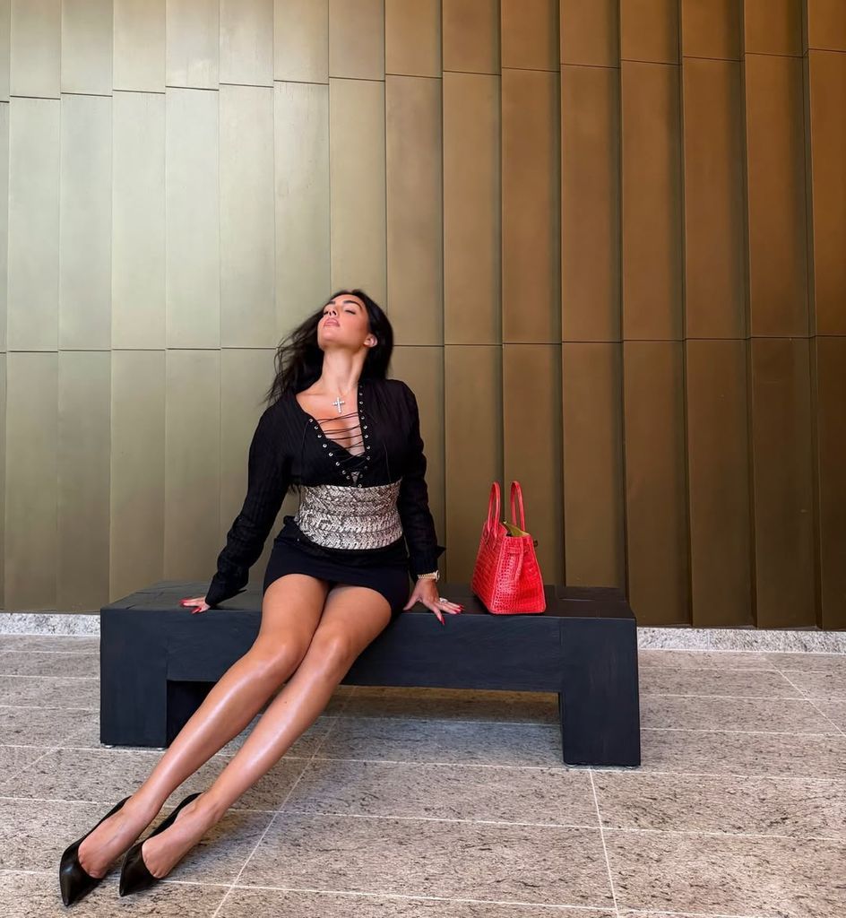The influencer completes her look with diamonds, high heels, and a luxury red handbag.