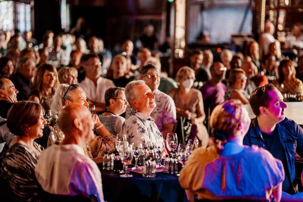 Audience members laughing during a stand up show