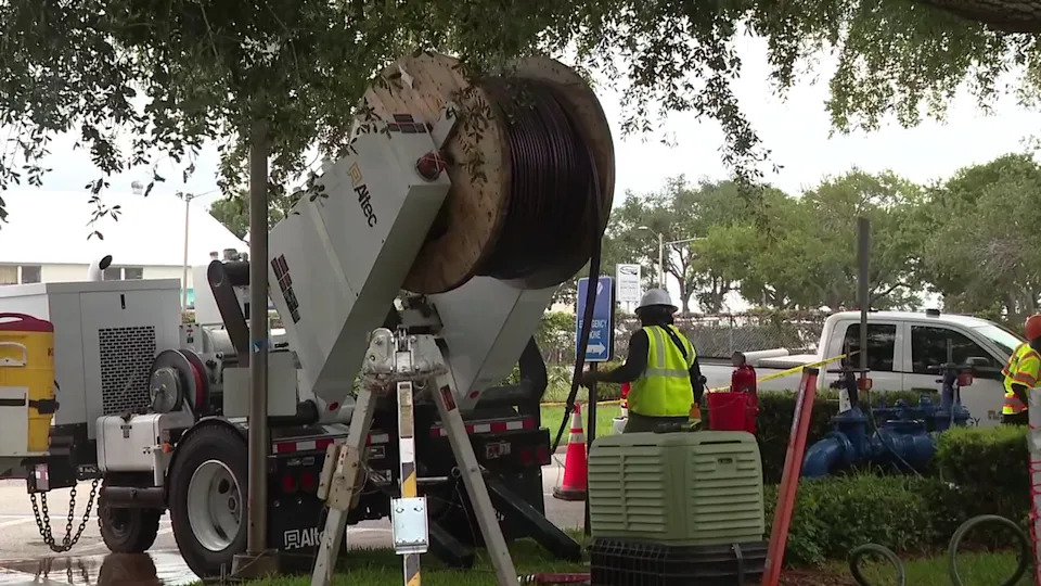 <div>A Duke Energy utility vehicle stands ready on a city street with a massive spool of heavy-duty electrical cable during infrastructure upgrades.</div>