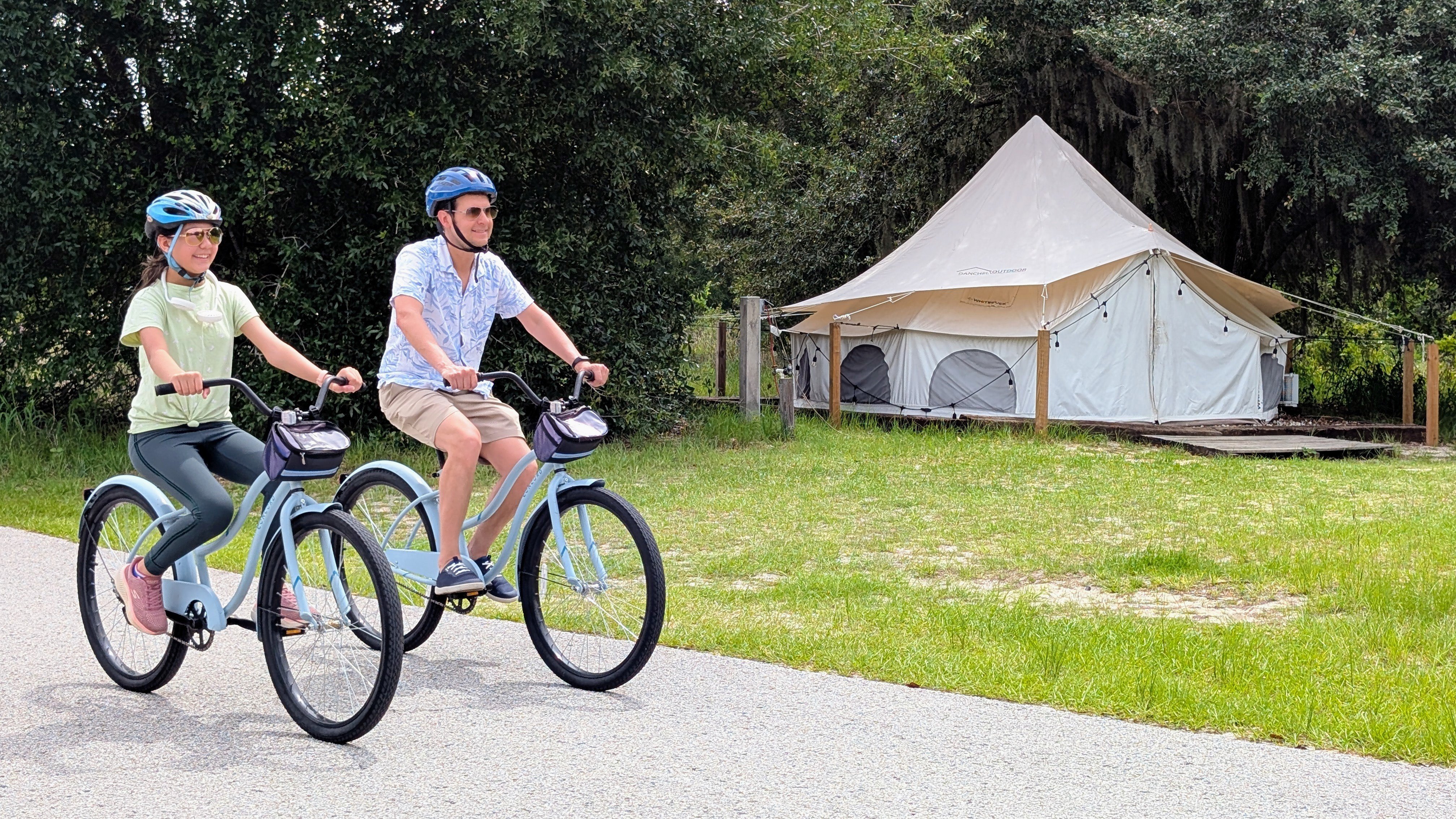 Family biking near glamping tents at Lake Louisa State Park