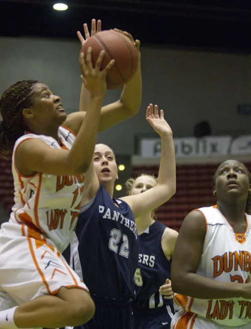 Dunbar High School's Kiara Desamours (12) goes up for a basket as Coral Springs Charter School's Karen Vardi (22) tries to defend during their FHSAA Girls Basketball 4-A semifinal game at the Lakeland Center Wednesday. February 22, 201